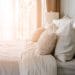 light soft pillow on beautiful bed cozy bedroom with sun light from window interior concept