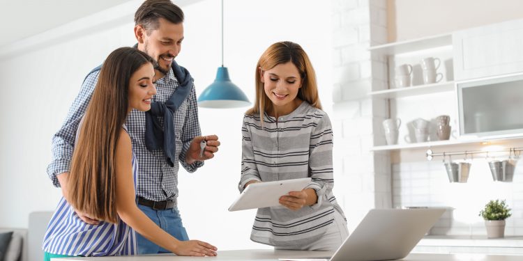 Female real estate agent working with couple, indoors