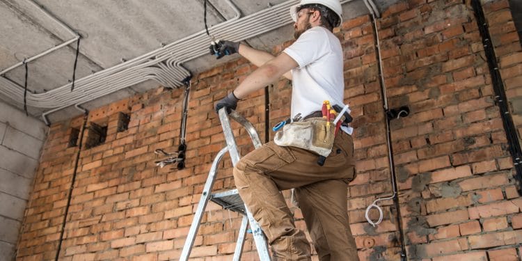 Electrician with tools, working on a construction site. Repair and handyman concept. House and house reconstruction.