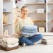 Woman with stacks of clean clothes at home