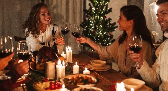 A group of women sitting at a table with food and wine glasses Description automatically generated