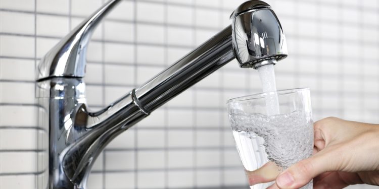 Filling glass of water from stainless steel kitchen faucet