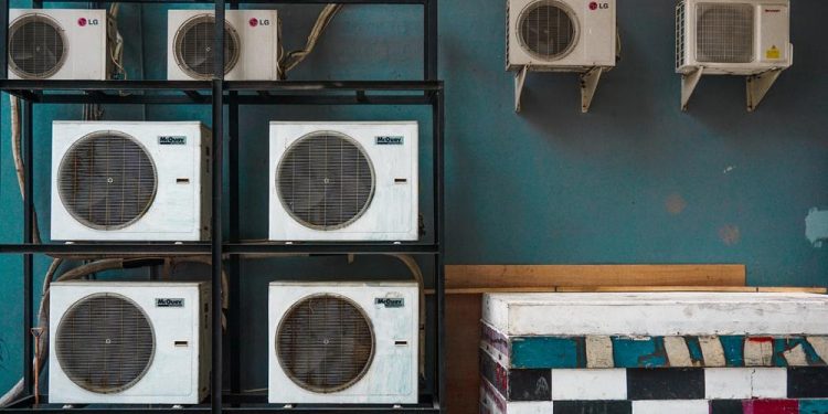 white and black box fan on brown wooden shelf