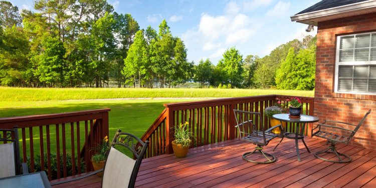 Residential backyard deck overlooking lawn and lake