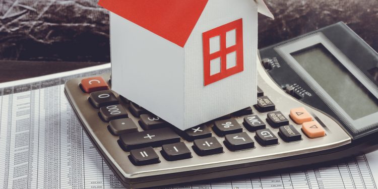 Real estate investment. House, key and calculator on table. Concept home loans