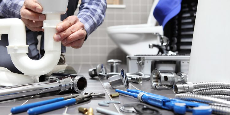plumber at work in a bathroom, plumbing repair service, assemble and install concept